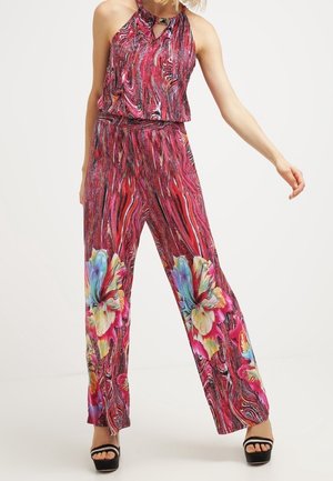 Combinaison multicolore avec un col halter, présentant un motif tourbillonnant rose et rouge rehaussé de grandes fleurs. Fabriquée en tissu léger.