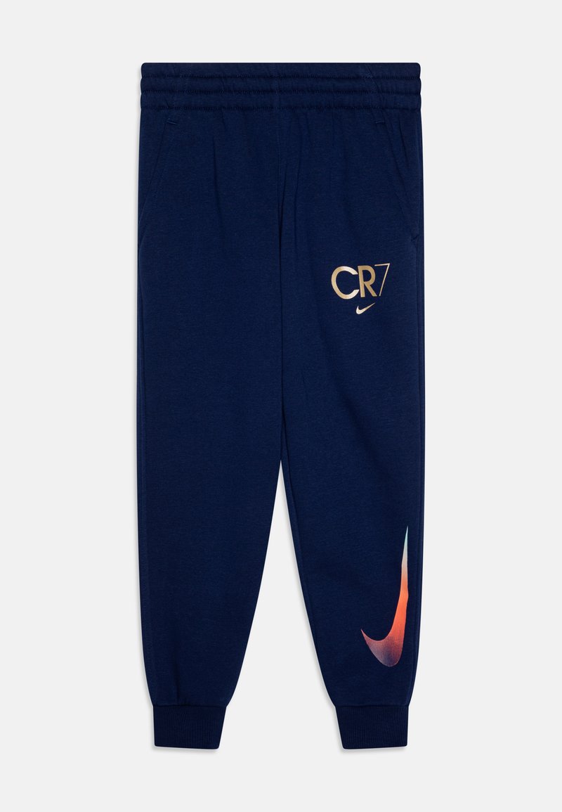 Tmavomodré tepláky so širokým elastickým pásom, zlatým nápisom "CR7" a malým logom Nike na stehne, a veľkým oranžovým logo swoosh Nike na dolnej časti nohy.
