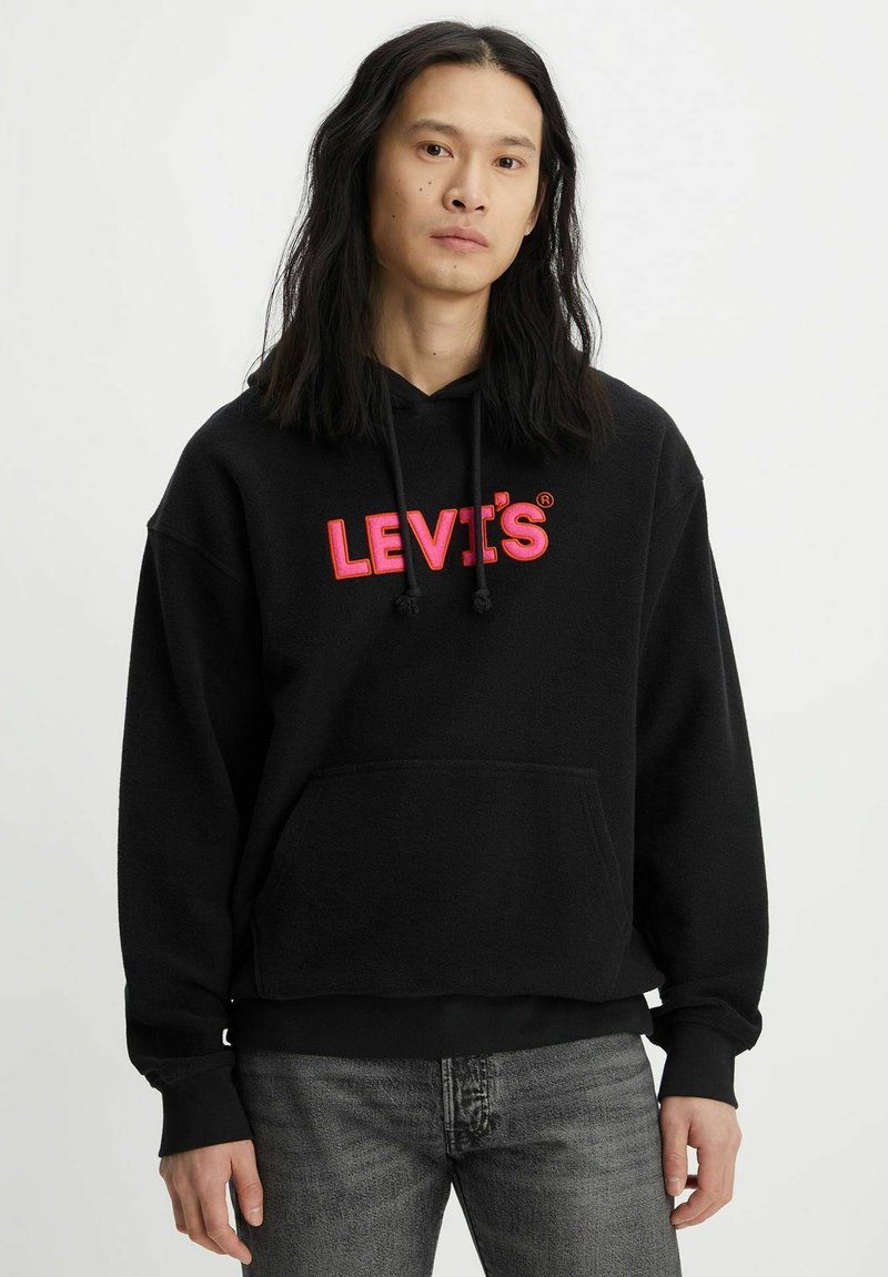 Felpa nera con cappuccio e tasca frontale, caratterizzata da un grande logo rosso "LEVI'S". I cordini regolabili e i polsini a coste completano il design.