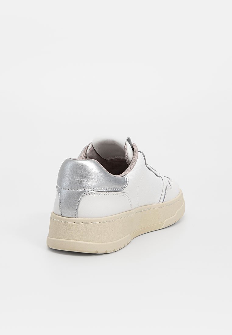 Witte sneaker met metallic zilveren accenten op de hiel, textuurleer bovenkant en een lichtbeige rubberen zool. Rond ontwerp en lage stijl.