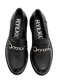 Zwarte loafers van textuurleer met een ronde neus, voorzien van een zilveren kettingaccent aan de voorkant en platte rubberen zolen.
