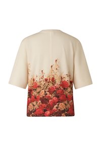 Sweter z krótkim rękawem w kremowym kolorze z kwiatowym wzorem na dole, przedstawiającym czerwone i różowe róże, gładką dzianinową fakturą oraz luźnym krojem.