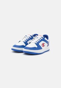Blå og hvite sneakers med en glatt lærfinish, med perforeringer på tåen, hvite lisser og en gummisåle. Rød logo aksent.