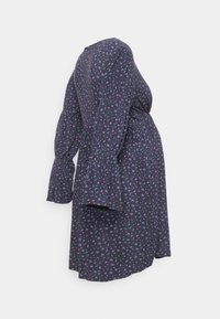 Vestido de maternidade em azul-marinho escuro com um padrão floral em púrpura e verde. Apresenta mangas em sino e uma cintura franzida para conforto.