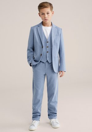 Helesinine ülikond, millel on keha jälgiv jakk ja sobivad püksid. Kangas on tekstuuriga ja sile, sisaldades kolme nupuga vest ja valget t-särki.