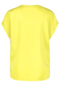 Blouse jaune à manches courtes, texture lisse, coupe ample, encolure ronde, ourlet droit, sans motifs ni ornements visibles.