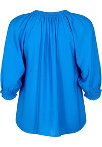 Túnica azul con un corte relajado y escote fruncido. Presenta mangas largas tipo globo con puños elásticos y un dobladillo ligeramente curvado.