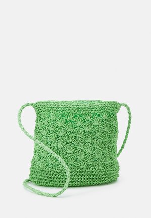 Petit sac seau vert en crochet avec une longue bandoulière tressée et un motif texturé en forme de fleur.