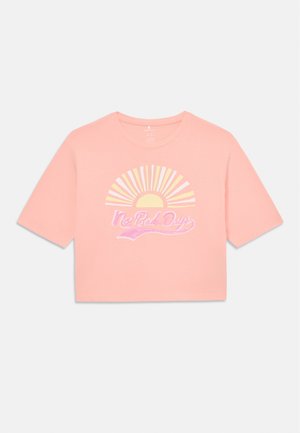 T-shirt cropped rosa feito de um tecido suave, apresentando um gráfico de um sol com raios em amarelo, e o texto "No Bad Days" em letra cursiva abaixo.