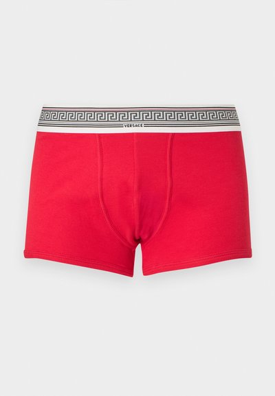 Boxers rouges pour hommes avec une ceinture blanche ornée d'un motif grec noir et le logo "Versace" centré à l'avant.