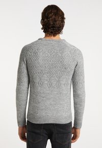 Maglione grigio a maglia con un motivo testurizzato e accenti a forma di diamante, polsini e orlo a costine. Collo rotondo, maniche lunghe aderenti.