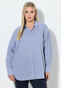 Koszula na guziki w paski w kolorze niebiesko-białym, wykonana z bawełny, z klasycznym kołnierzykiem, długimi rękawami i luźnym krojem z zakrzywionym dołem.