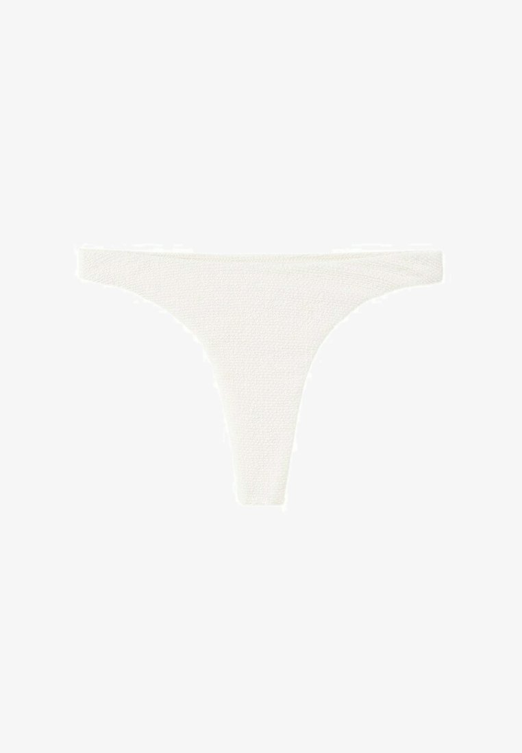 Culotte blanche texturée de style tanga, avec une ceinture étroite et des ouvertures de jambe échancrées, présentée à plat sur un fond blanc.