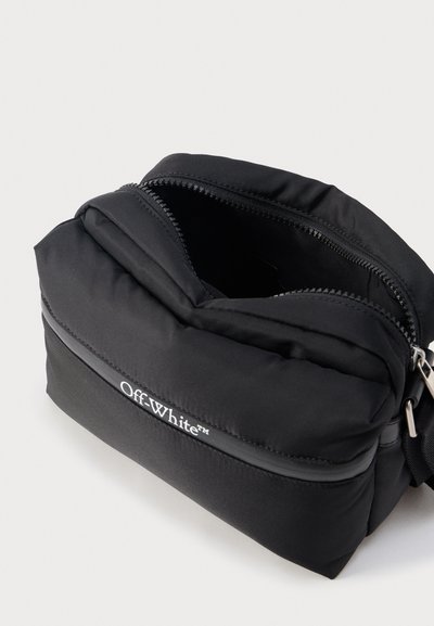 Μαύρο τσαντάκι με φερμουάρ επωνυμίας Off-White με το κύριο διαμέρισμα ανοιχτό, που δείχνει λείο ύφασμα και ασημένια λαβή φερμουάρ σε ανοιχτό φόντο.