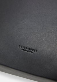 Svart texturerat läderprodukt med den präglade logotypen "SEIDENFELT MANUFAKTUR". Slät yta med lätt glans och hållbart utseende.