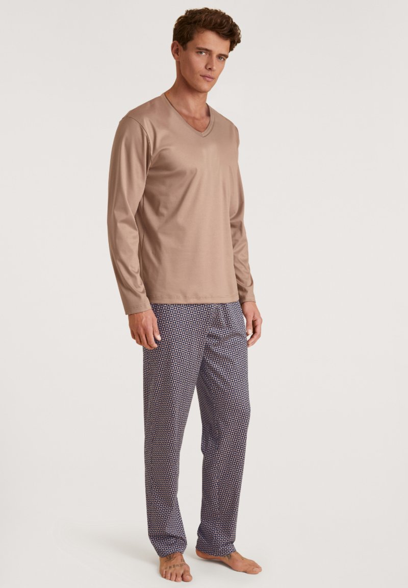 Heren loungewear set met een lange mouwen beige V-hals top en marineblauwe broek met een geometrisch patroon. Zachte stof en relaxte pasvorm.