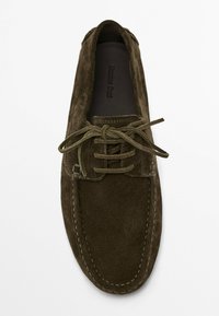 Scarpa da barca in suede verde scuro con punta arrotondata, chiusura con lacci, lacci abbinati e cuciture a contrasto lungo il bordo.