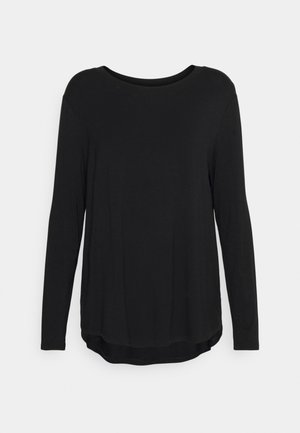 Zwart shirt met lange mouwen en ronde hals, met een licht gebogen zoom en een losse pasvorm, getoond tegen een effen lichtgrijze achtergrond.