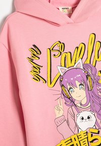Sudadera rosa con un diseño gráfico de un personaje con cabello morado, auriculares y un gato, acompañado de texto en amarillo.