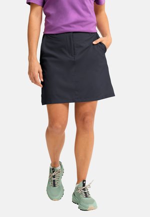 Black, knee-length skirt with a front pocket, paired with green hiking shoes. The skirt features a smooth texture and simple design.
