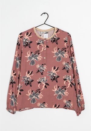 Blusa a maniche lunghe in malva con stampa floreale. Presenta un collo rotondo, chiusura con bottoni e polsini elasticizzati. Tessuto morbido con una consistenza leggera.