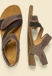 Hnědé kožené sandály se dvěma černými řemínky, texturovanou stélkou a polstrovanou podešví. Otevřený design s výřezy pro prodyšnost.