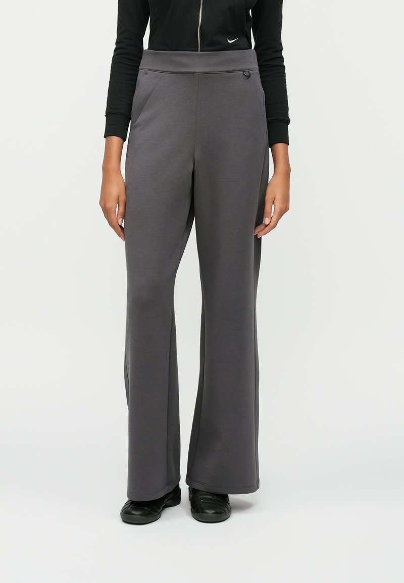 Γκρι παντελόνια σε φαρδιά γραμμή, κατασκευασμένα από μαλακό ύφασμα, με ψηλή μέση, πλαϊνές τσέπες και λεία υφή. Συνδυασμένα με μαύρα παπούτσια.