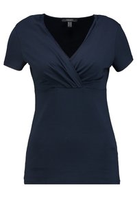 Mörkblå kortärmad topp med V-ringning, som har en vriden framdesign. Tillverkad av mjukt, stretchigt tyg med en slät yta.