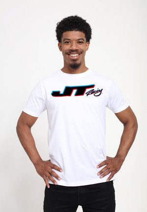 Hvid bomulds t-shirt med et stort sort-og-blått grafisk logo "JT Racing" på fronten. Korte ærmer og rund hals design.