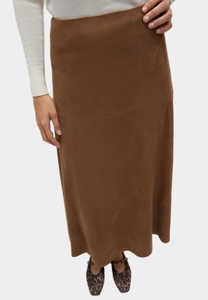 Longue jupe maxi en daim marron avec une texture lisse et des détails de couture. Assortie à des chaussures à imprimé léopard noir et marron pour un contraste.