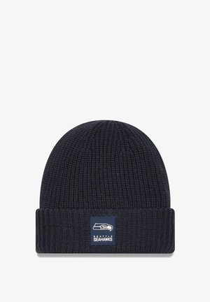 Bonnet en tricot bleu marine avec un design côtelé et un revers replié, arborant une patch carrée avec le logo des Seattle Seahawks à l'avant.