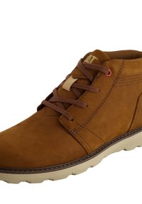 Botas de cuero marrón hasta el tobillo con un acabado texturizado, cordones marrones y una suela de goma beige. Presenta un pequeño logo y detalles de costura visibles.