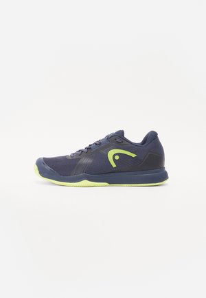 Granatowe buty sportowe z neonowozielonymi akcentami. Posiadają siateczkowy wierzch, wyściełaną podeszwę oraz sznurowane zapięcie. Okrągły czubek i teksturowana podeszwa.