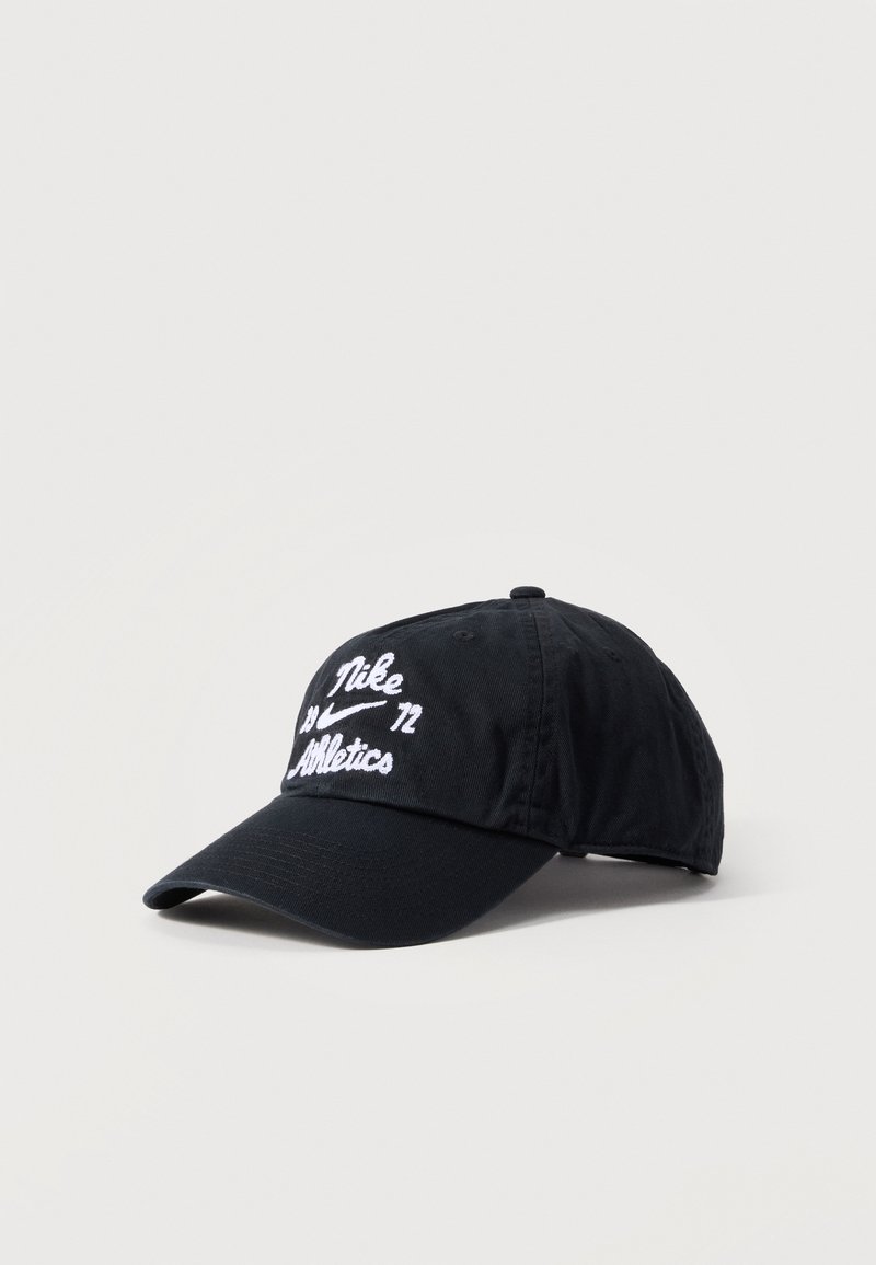 Gorra de béisbol negra de Nike con texto y logotipo bordados en blanco "Nike Athletics", mostrada sobre un fondo claro y sencillo.