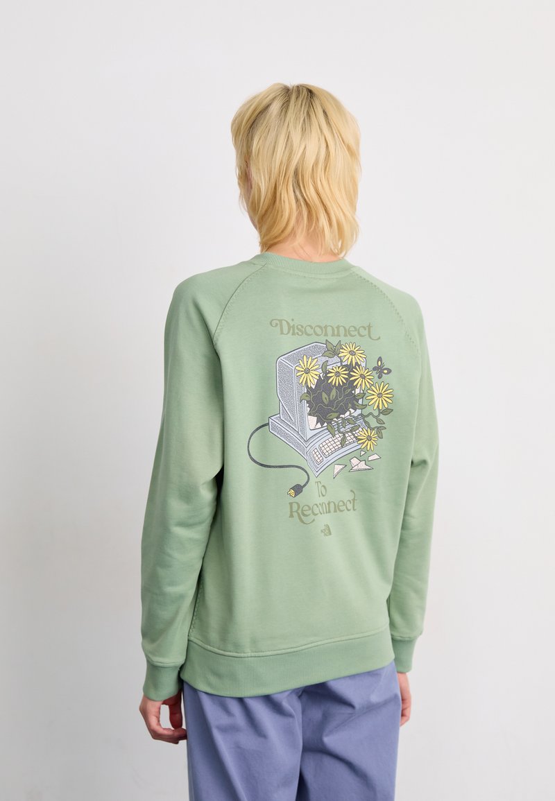 Sweat-shirt vert à manches longues, col rond, avec un graphique d'un ordinateur entouré de fleurs. Le texte indique "Déconnectez-vous pour vous reconnecter." Texture douce.