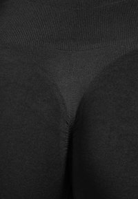 Leggings neri con una texture liscia, con una fascia alta in vita e una vestibilità aderente. Il materiale sembra elastico con una finitura opaca.