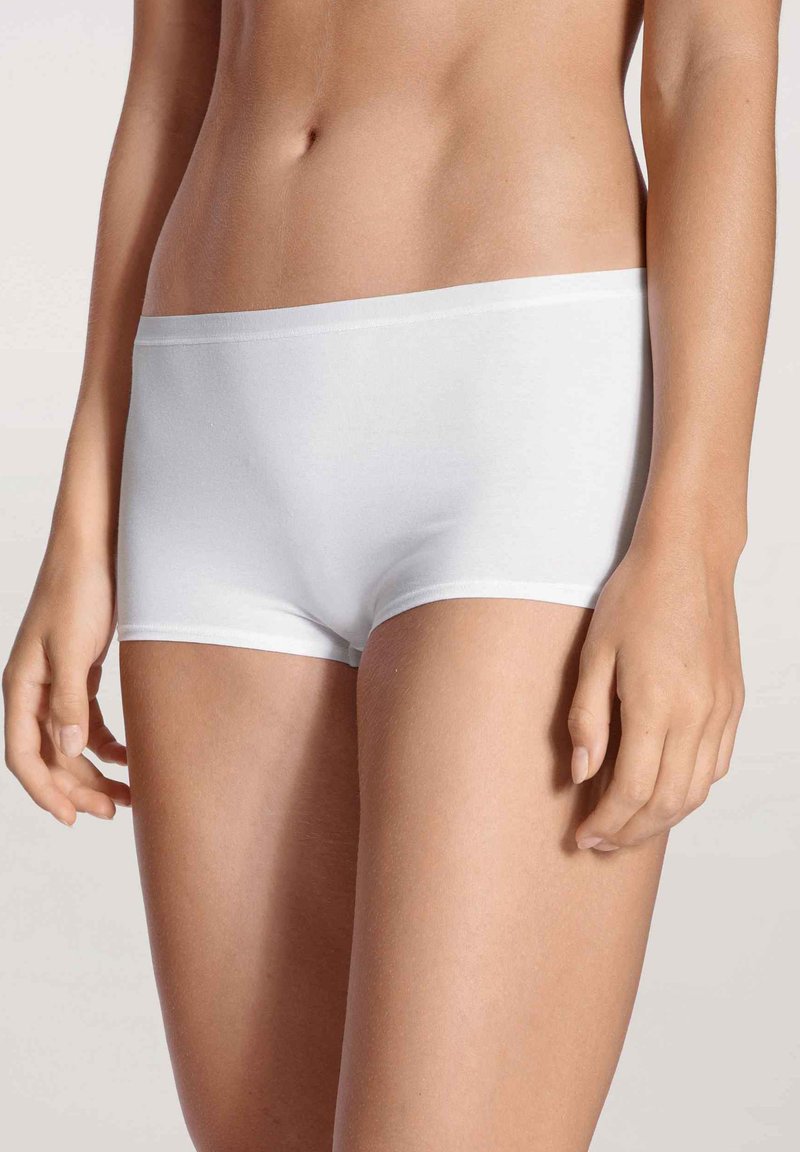 Weiße Baumwoll-Boyshorts mit glatter Textur und elastischem Bündchen, die ein einfaches Design aufweisen und bequem auf den Hüften sitzen.