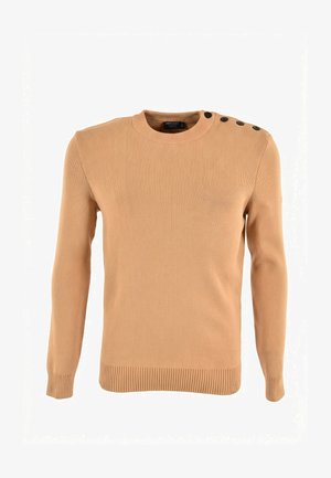 Lichtbruine geribbelde gebreide trui met ronde hals, lange mouwen en vier zwarte knopen op de linkerschouder.