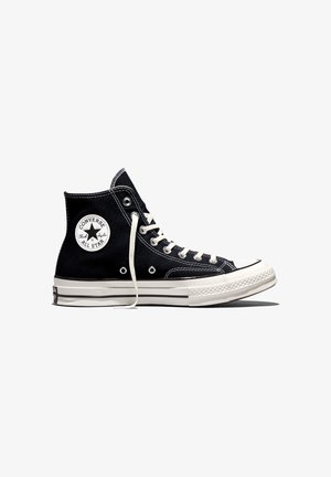 Czarny wysoki sneaker Converse Chuck Taylor All Star z białymi sznurówkami i gumową podeszwą, pokazany z boku na białym tle.