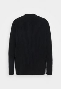 Svart ribbad tröja med långa ärmar och rund halsringning. Har ett strukturerat tyg och en något lös passform. Inga synliga knäppningar.