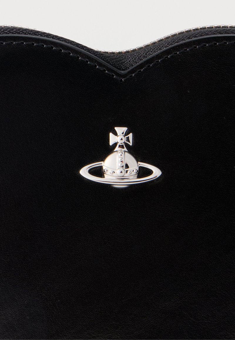 Superficie in pelle nera con un emblema d'argento che presenta un globo stilizzato, un anello e una croce al centro del bordo superiore.