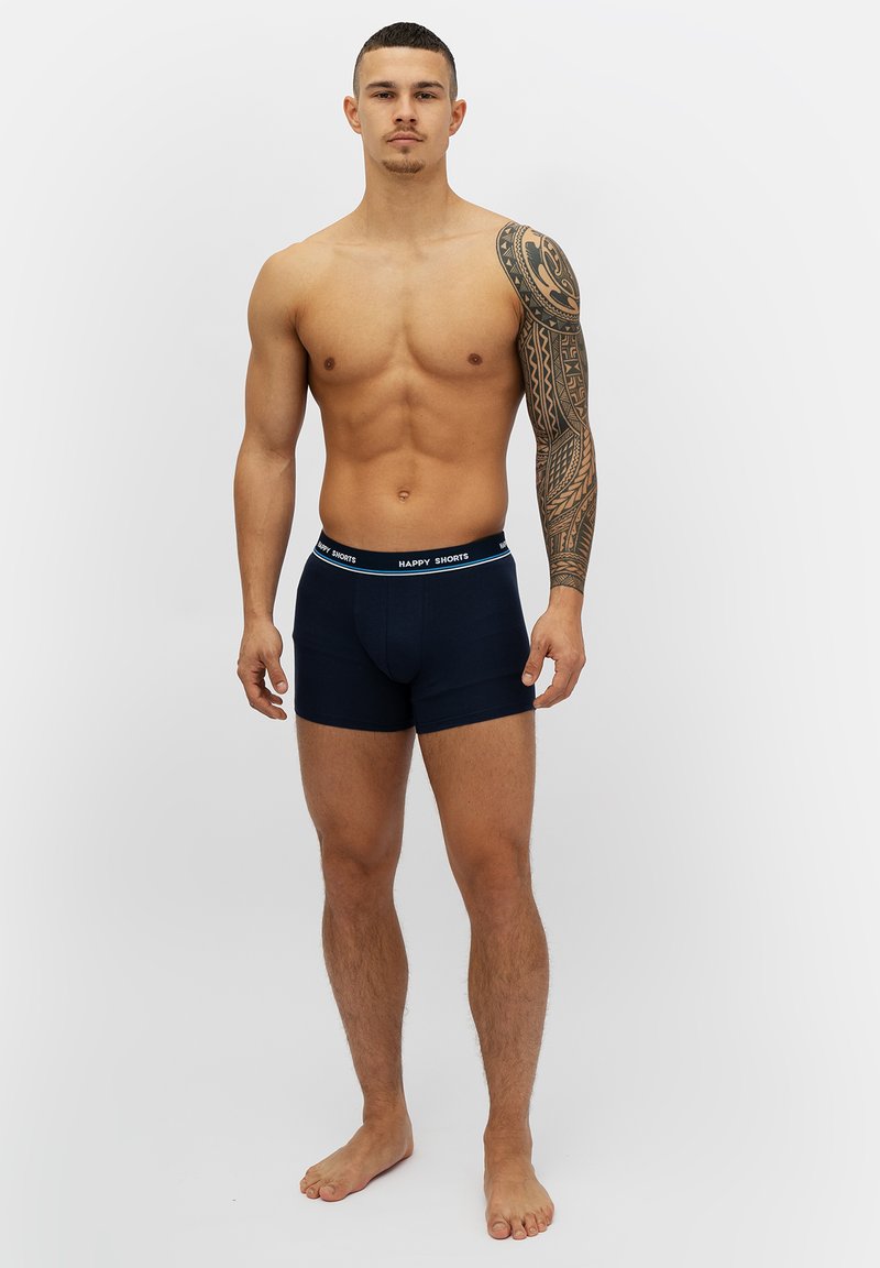 Marinblå kalsonger med mjukt tyg och en elastisk midja med texten "HAPPY SHORTS." Denal designen inkluderar en nära passform och korta ben.