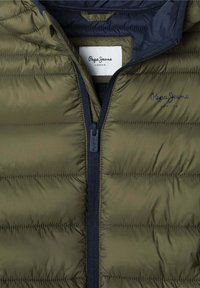 Olive zelena puhala jakna s mornarsko modrim zadrževalnikom, ki ima vodoravne quilted odseke in oznako "Pepe Jeans London" na notranji ovratniku.