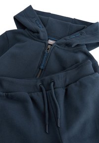 Set format din hanorac și pantaloni sport, culoare bleumarin. Hanoracul are fermoar frontal, guler cu tiv striat și șnururi. Material neted, cu manșete și talie elastice.