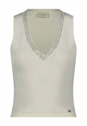 Top senza maniche in maglia color crema con scollo a V decorato con piccoli borchietti argentati e una piccola targhetta con logo metallico sull'orlo inferiore.