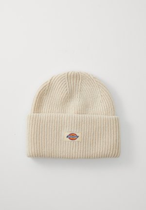Cremefarvet ribstrikket hue med ombuk og et lille rektangulært Dickies-logo patch centreret på ombukket.