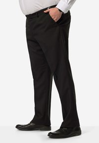 Pantaloni neri in tessuto liscio, con una vestibilità su misura, tasche laterali e abbinati a scarpe eleganti nere.