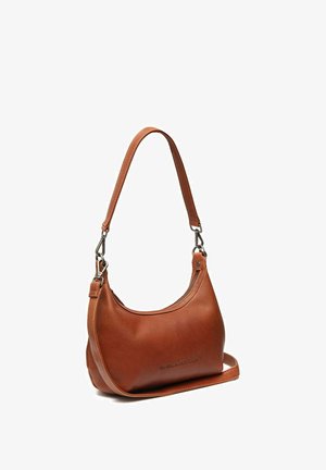 Sac à bandoulière en cuir marron avec une forme courbée, un détail zippé et une longue bandoulière. Présente des accents en métal.