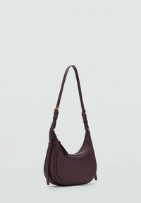 Dark purple leather shoulder bag with a curved shape, adjustable strap, and gold-tone hardware accents. Smooth texture with minimal detailing.