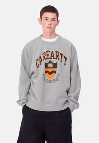 Felpa grigia con un collo arrotondato, caratterizzata dalla scritta "CARHARTT" in arancione e un design a scudo con un motivo arancione e nero.